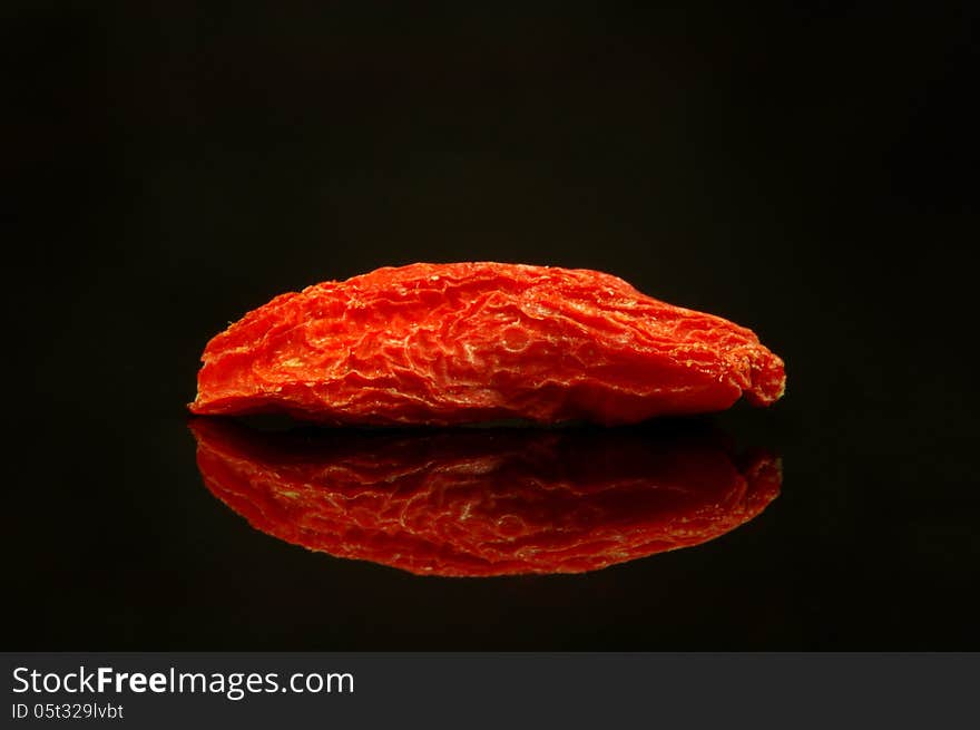 The photograph shows the goji berry umiszczoną on czrnym mirrored background. The photograph shows the goji berry umiszczoną on czrnym mirrored background.