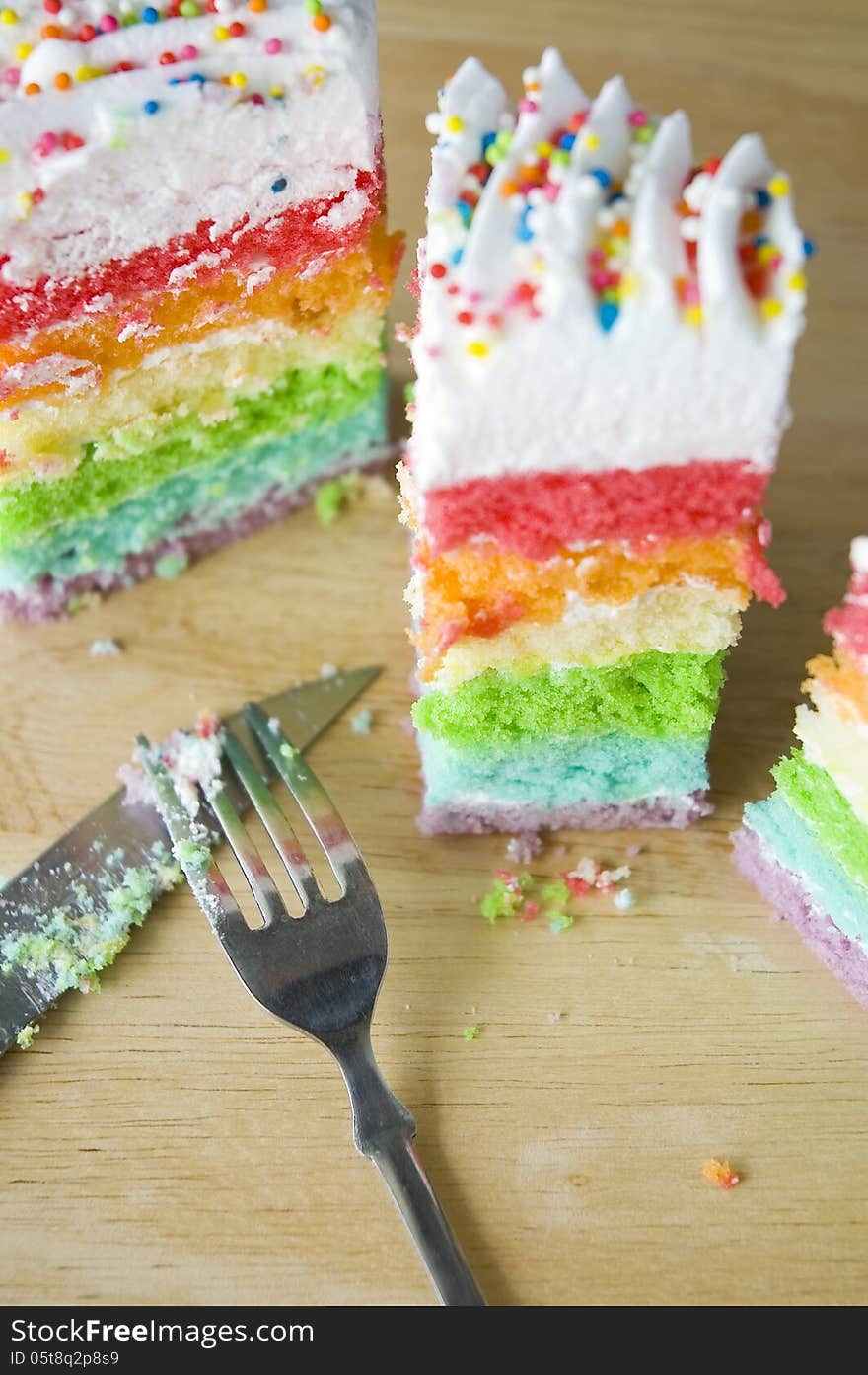 Pieces of rainbow cake with fork and knife. Pieces of rainbow cake with fork and knife