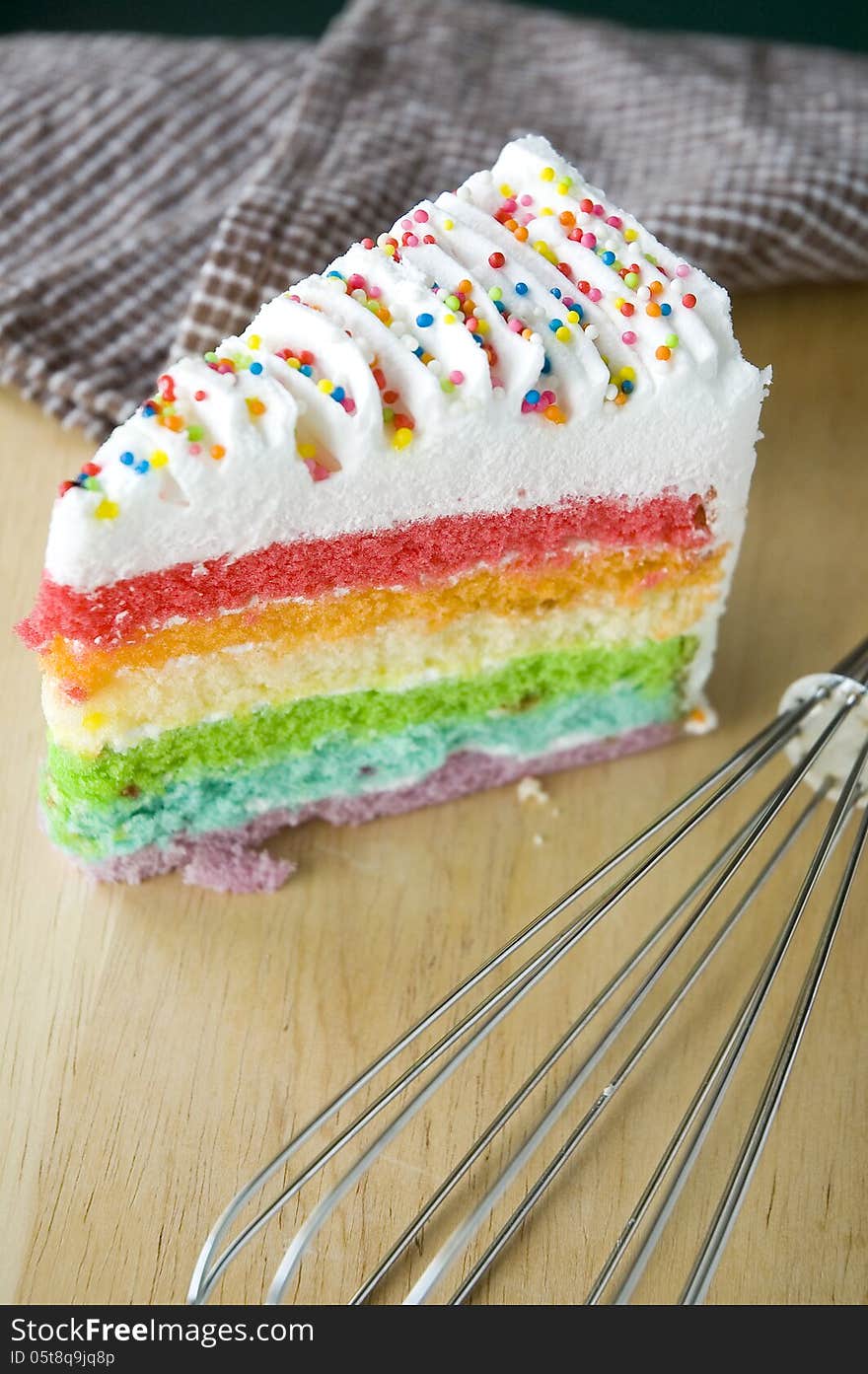 Rainbow cake put on wooden table with kitchenware. Rainbow cake put on wooden table with kitchenware