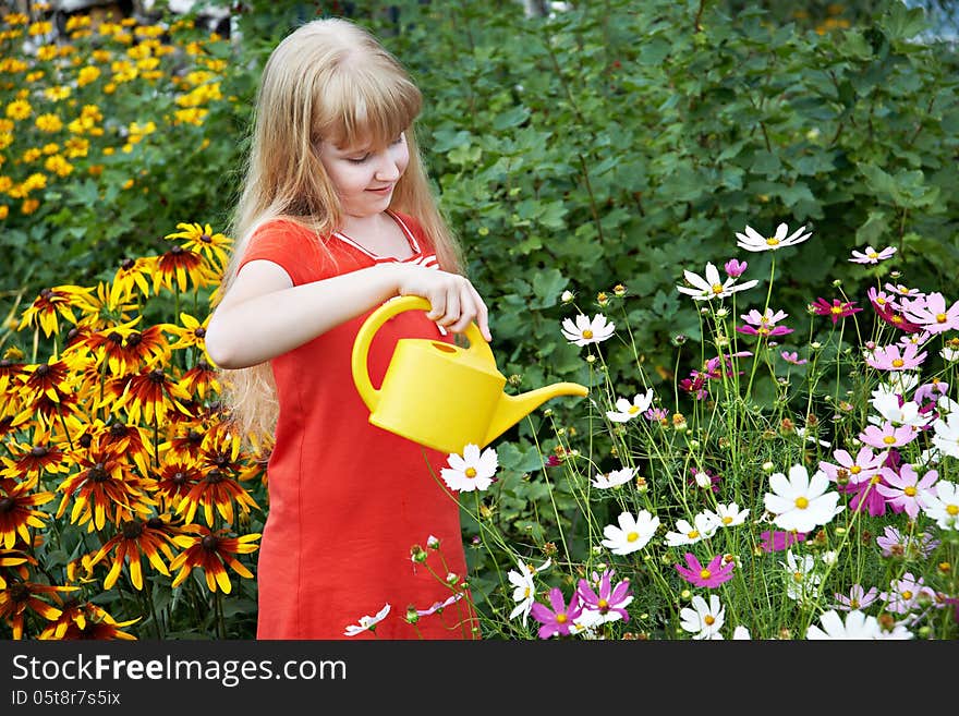 Little girl watering flowers