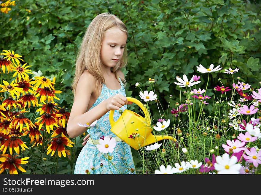 Little girl watering flowers