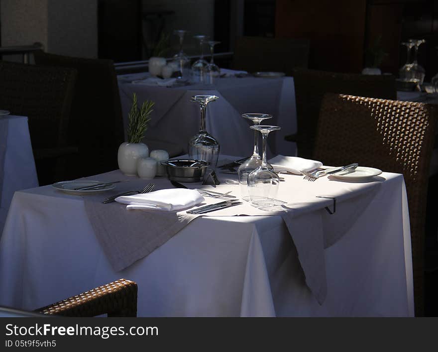 Stylish terrace restaurant table with glasses and cutlery waiting for guests. Stylish terrace restaurant table with glasses and cutlery waiting for guests