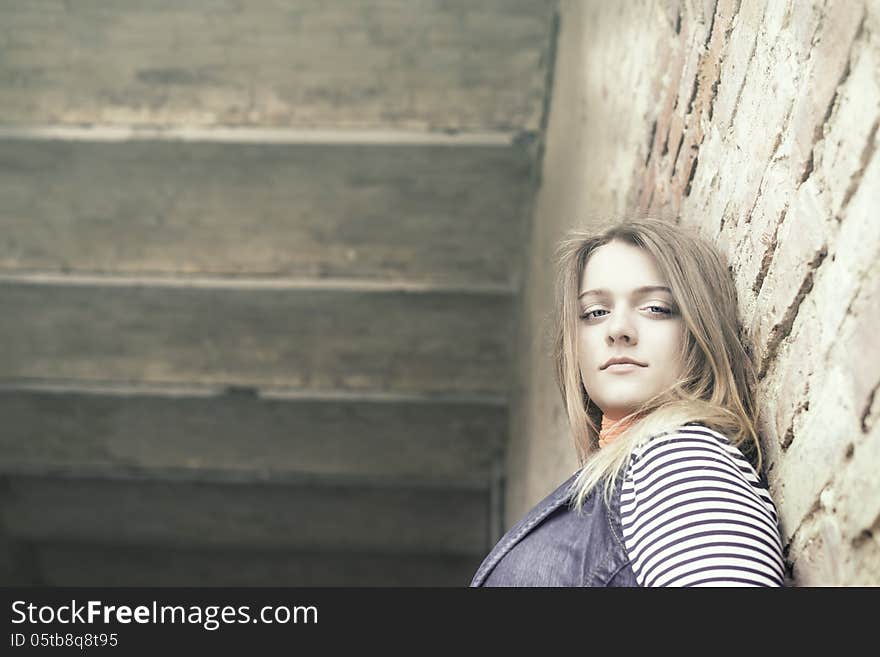 Beautiful girl out of door against a wall. Beautiful girl out of door against a wall