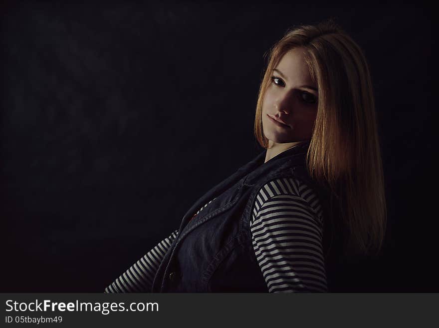 Portrait of beautiful thoughtful girl close up in the dark