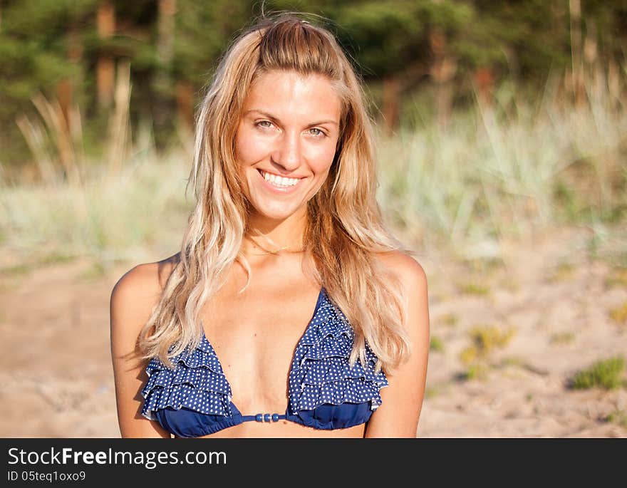 Young sensual woman in a blue bikini on the beach. Young sensual woman in a blue bikini on the beach