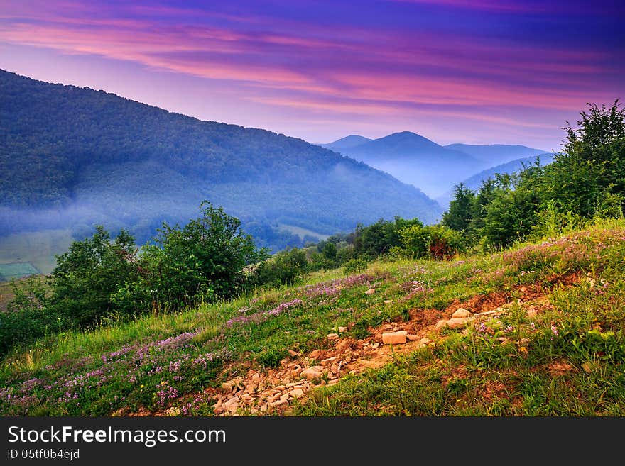 View of the mountains in the fog in the morning standing on a hillside. View of the mountains in the fog in the morning standing on a hillside