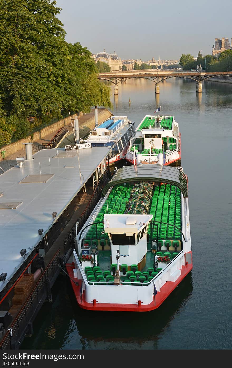 Tourist Boats waiting for sightseeing passengers on the Seine River, Paris France in portrait view.