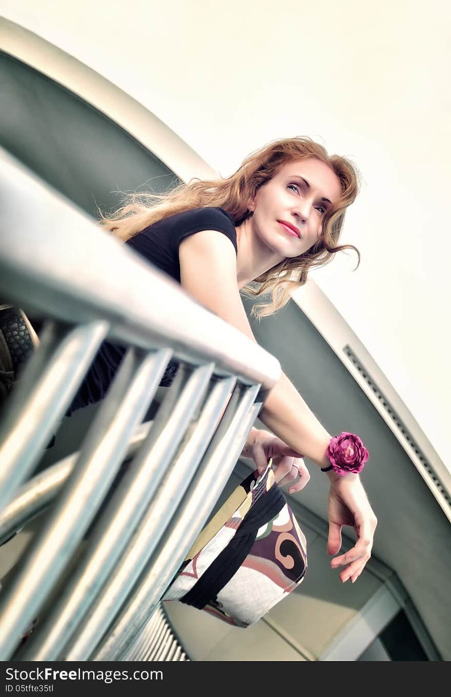 Portrait Of Thinking Beautiful Woman Standing On The Stairs