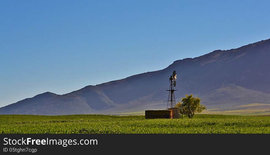 Landscape with hill and water pump windmill