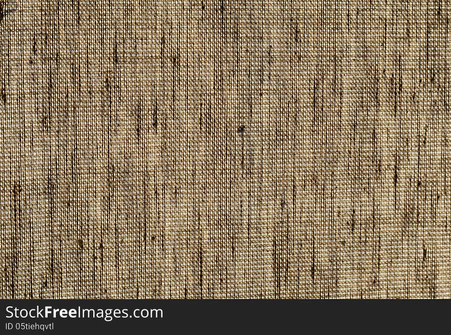 Rough light brown burlap fabric on a light background close-up. Rough light brown burlap fabric on a light background close-up