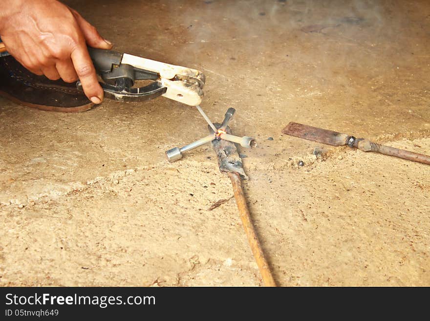 Welder man welding steel on cement floor with spread spark