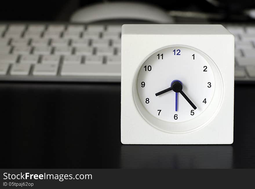 White clock, keyboard, business table in the office