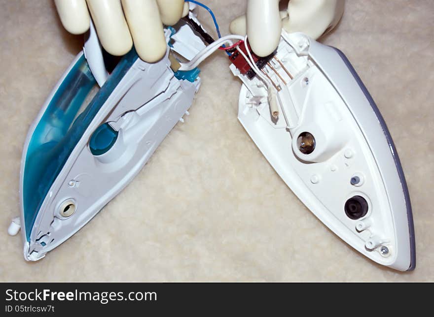 Disassembled iron has two main parts due to electricity special rubber gloves protect person