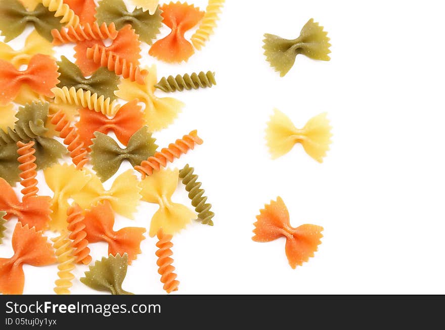 Different pasta in three colors on a white background