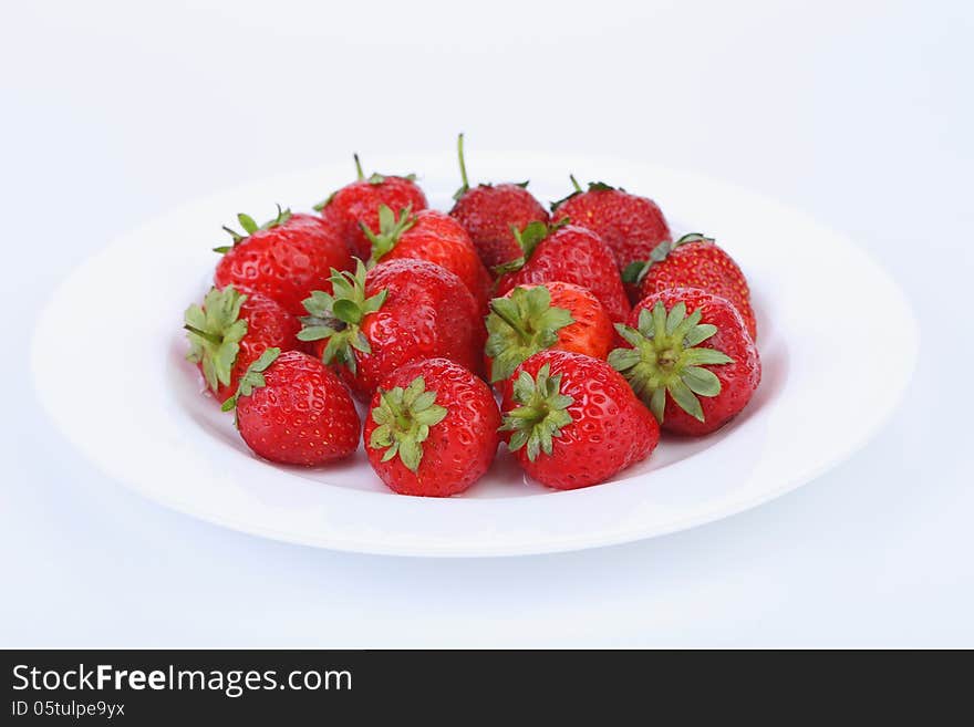 Fresh red ripe strawberries on a white plate. See my other works in portfolio.