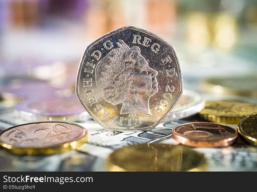 50 pence on top of various bills and coins