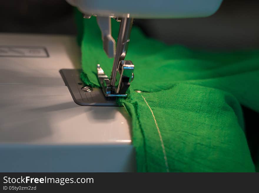 Sewing Process: green textile under the needle in the sewing machine