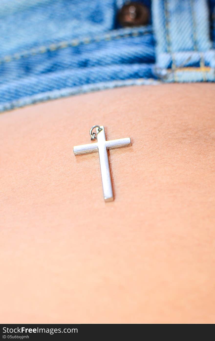 Silver cross put on body skin.