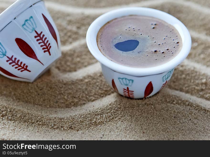 Espresso.Coffee in a small cup in the sand