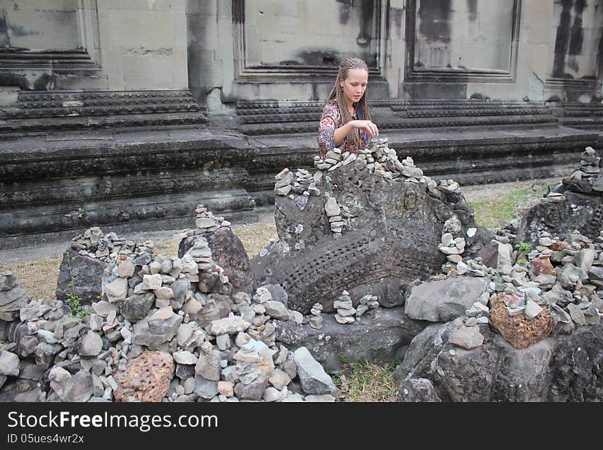 Girl sitting near the ancient walls of the temple. Girl sitting near the ancient walls of the temple