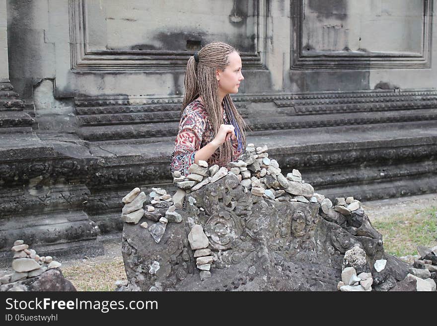 Girl sitting near the ancient walls of the temple. Girl sitting near the ancient walls of the temple