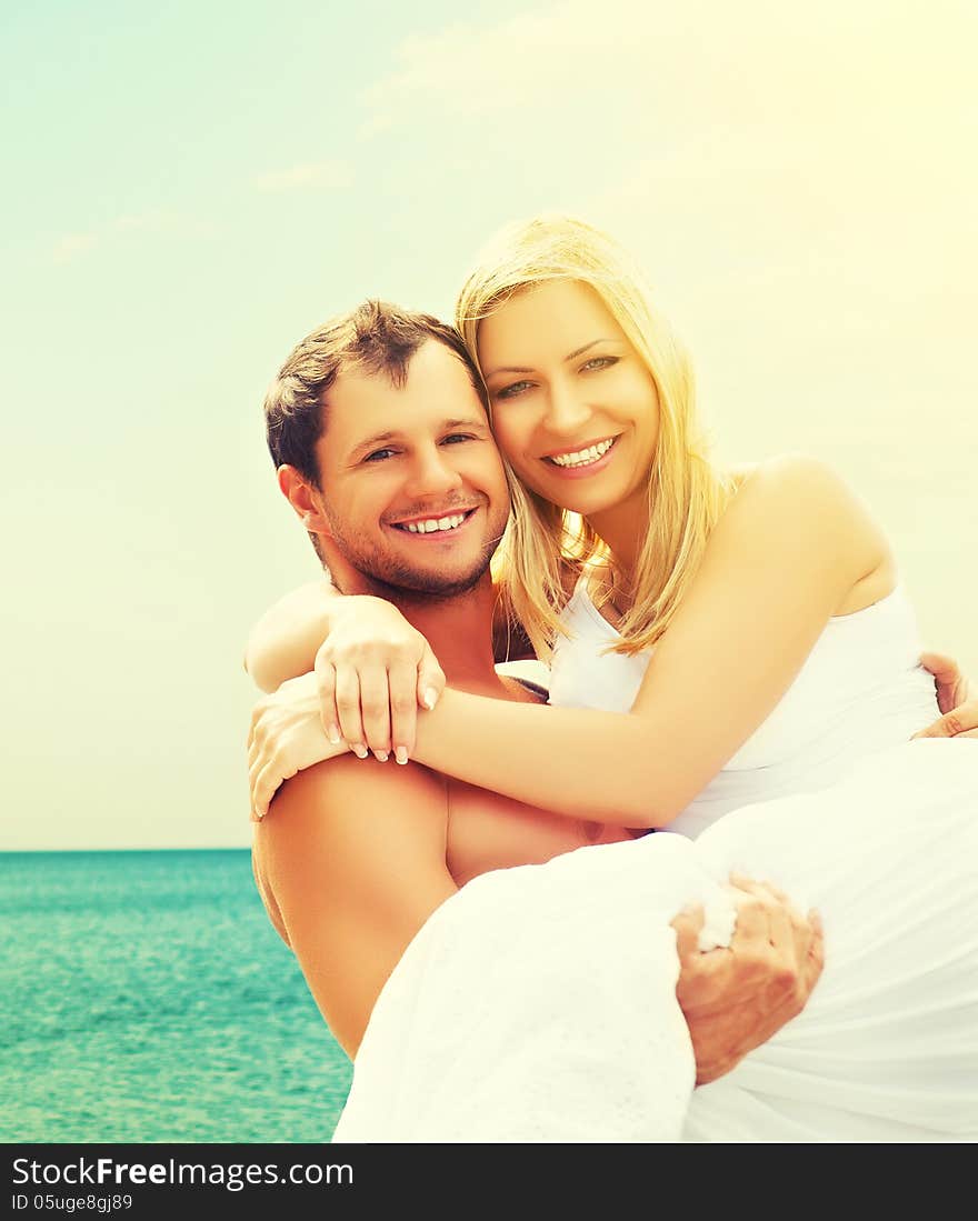 Happy Family Couple In Love Hugging And Laughing On The Beach