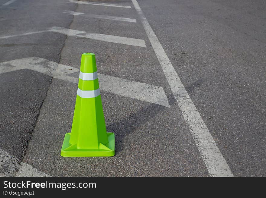 Green traffic cone. Placed on the road surface. Green traffic cone. Placed on the road surface