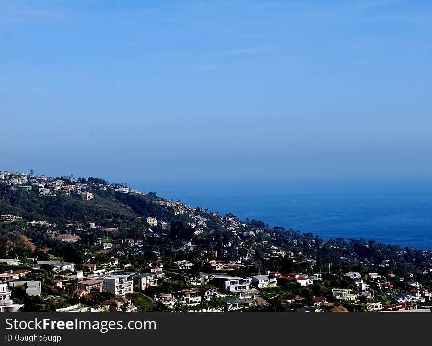 Panoramic ocean view of Laguna Beach from hilltop showing blue sky merging with the blue ocean