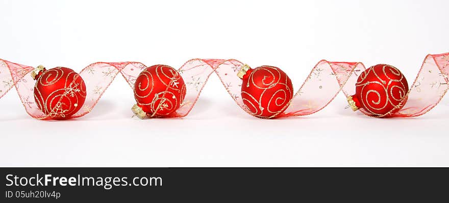 Red-golden baubles with the ribbon on the white background. Red-golden baubles with the ribbon on the white background