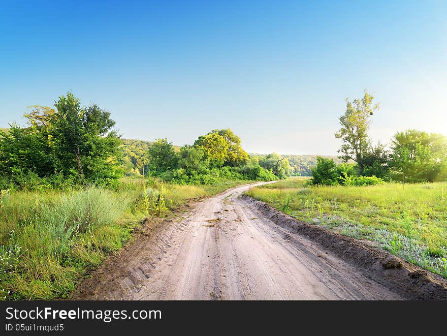 Winding road in a field at sunrise