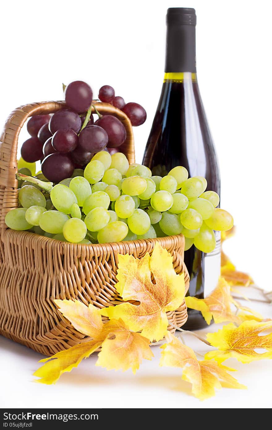 Bottle of wine with grapes in basket isolated on white