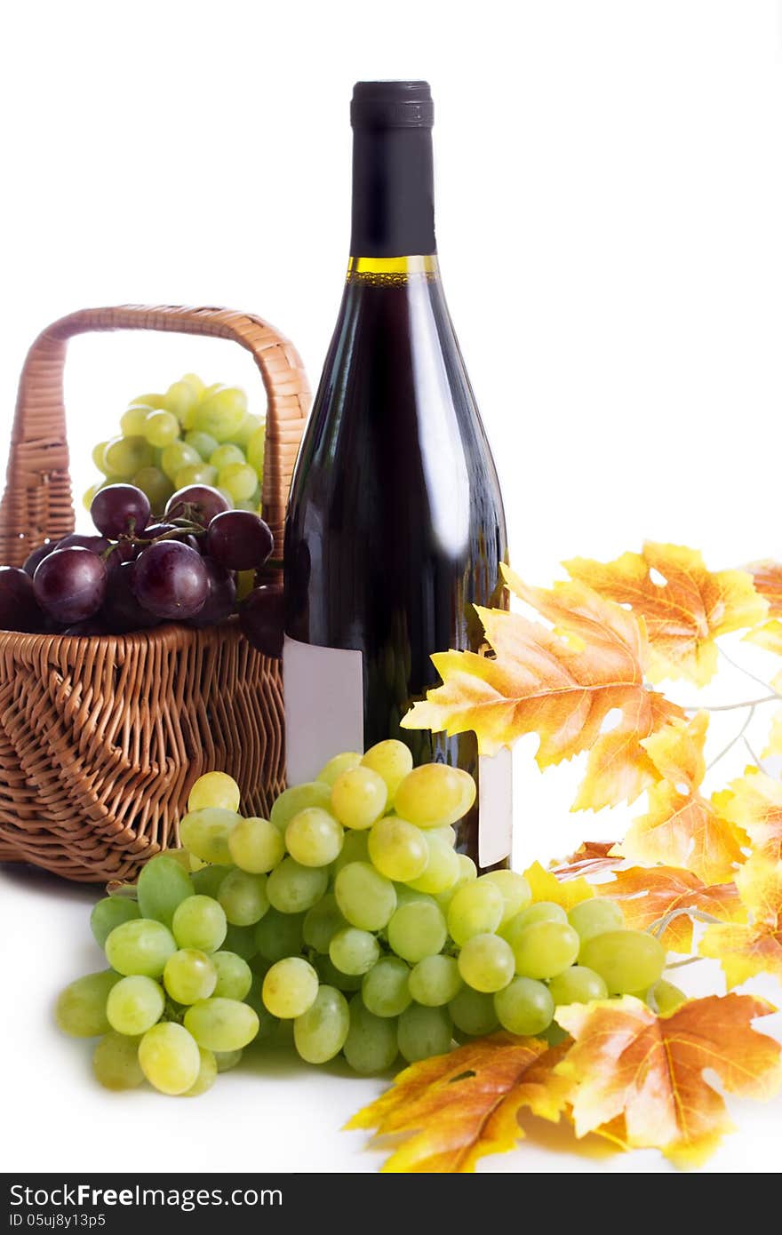 Ripe red and dark grapes and wine in basket isolated on white