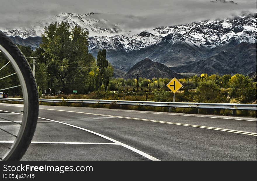 Beautiful mountain landscape, where you can see the imposing Andes Mountains with snowy peaks, on a cloudy day, with the green landscape of southern Mendoza, Argentina, an area with its charms for bike rides, through the vineyards and tourism wineries call Tunuyan. Beautiful mountain landscape, where you can see the imposing Andes Mountains with snowy peaks, on a cloudy day, with the green landscape of southern Mendoza, Argentina, an area with its charms for bike rides, through the vineyards and tourism wineries call Tunuyan