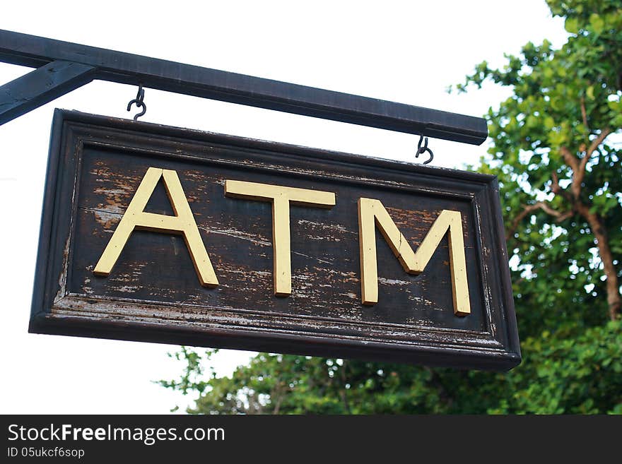 The wood atm sing with gold letter