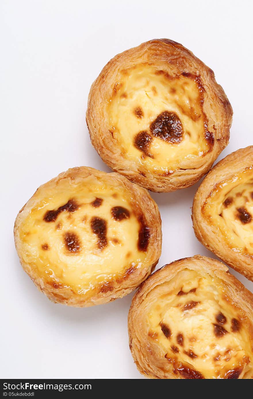 Portuguese egg tarts were evolved from pastel de nata, a traditional Portuguese custard pastry that consists of custard in a crème brûlée-like consistency caramelized in a puff pastry case. It was created more than 200 years ago by Catholic Sisters at Jerónimos Monastery at Belém in Lisbon. It is now a popular pastry in every pastry shop around the world owned by Portuguese descendants.