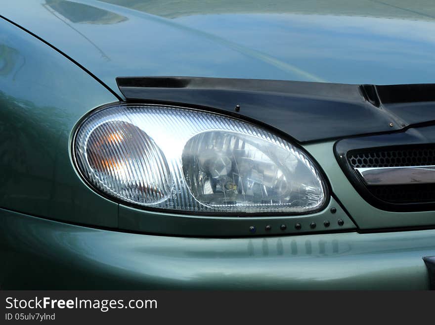 Fragment of a car. The right front headlight