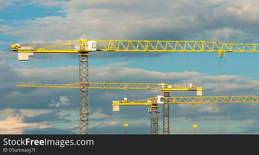 Building construction cranes against the cloudy sky. Building construction cranes against the cloudy sky.