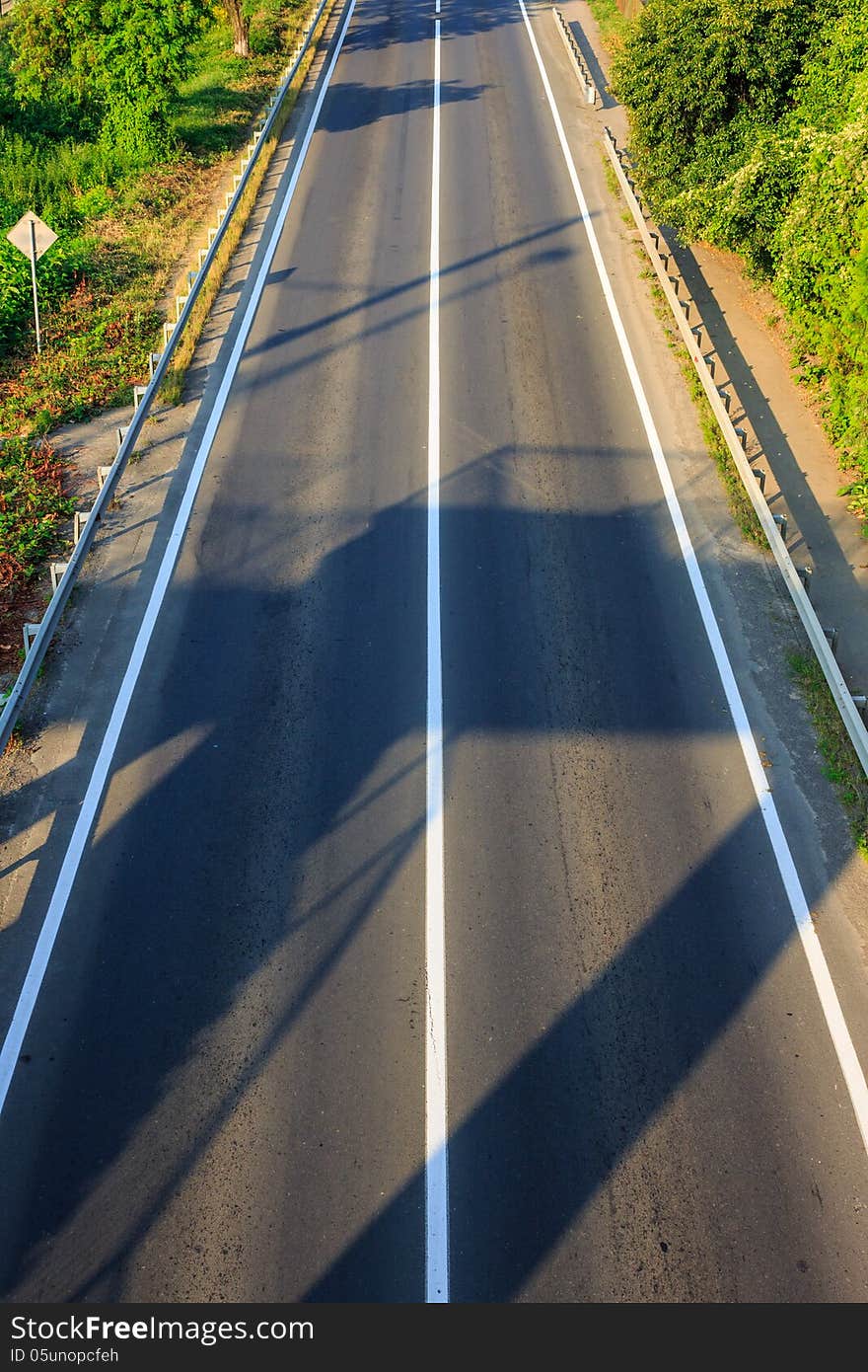 Shadow on an empty road early in the morning. view from the top. Shadow on an empty road early in the morning. view from the top