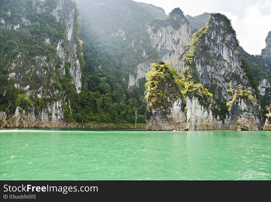 Beautiful high mountains and green river in the morning at Ratchaprapha Dam, Khao Sok National Park, Surat Thani Province, Thailand ( Guilin of Thailand ). Beautiful high mountains and green river in the morning at Ratchaprapha Dam, Khao Sok National Park, Surat Thani Province, Thailand ( Guilin of Thailand )