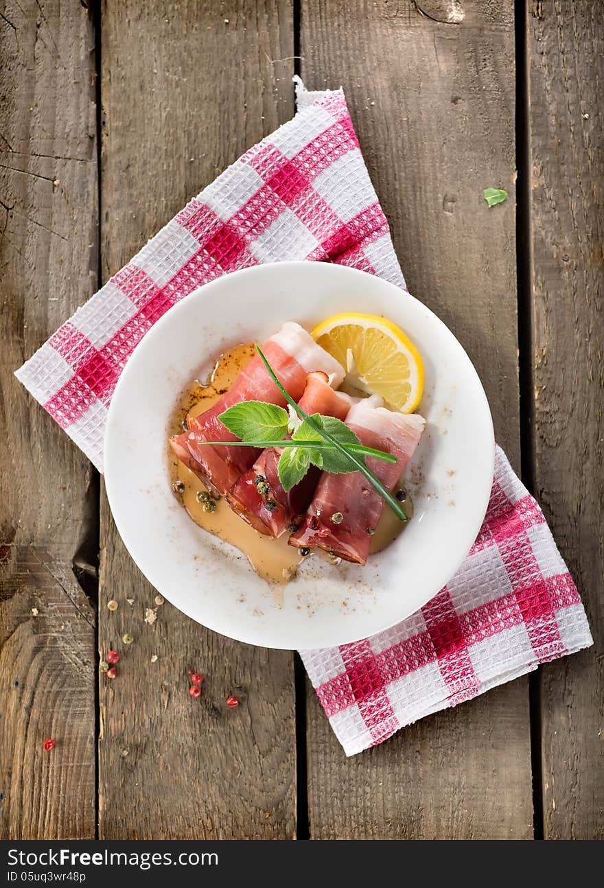 Bacon in plate on a wooden background