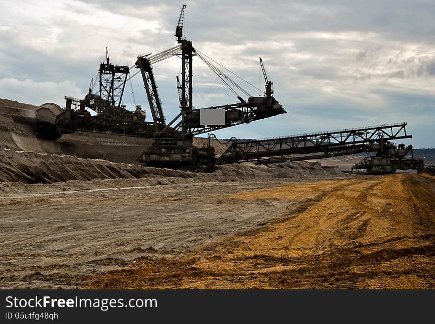 Enormous excavator at work in open coast coal mine. Enormous excavator at work in open coast coal mine