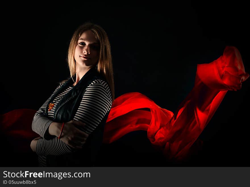 Beautiful girl against red fabric in the dark