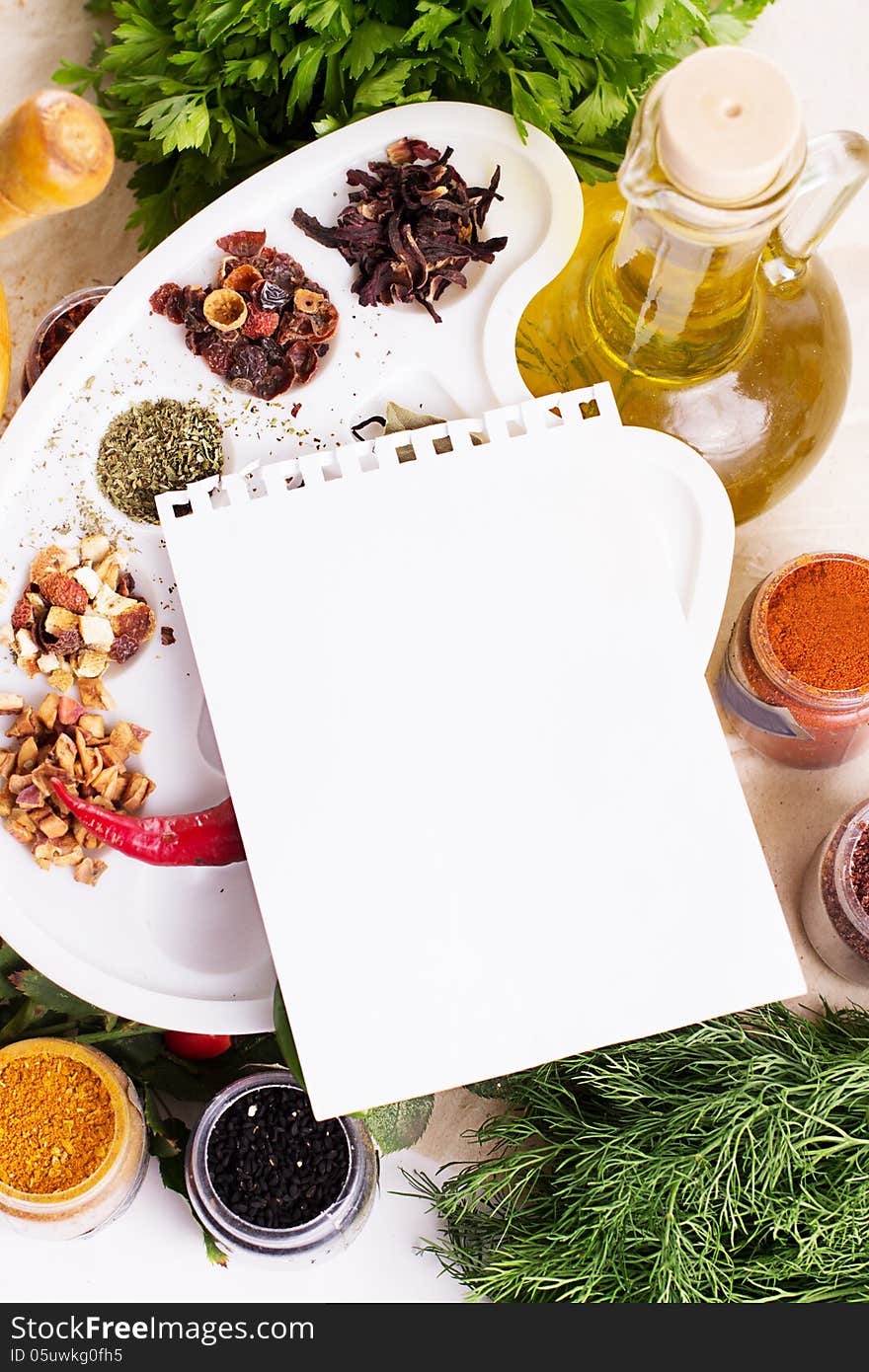 Blank notebook sheet with spices and herbs on the wooden board