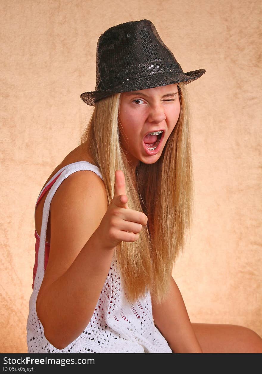 Teenage Female With Black Hat Winking And Pointing. Teenage Female With Black Hat Winking And Pointing