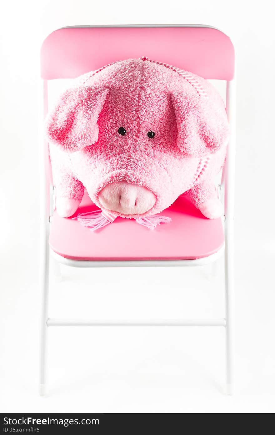 Pink fabric pig is on a chair