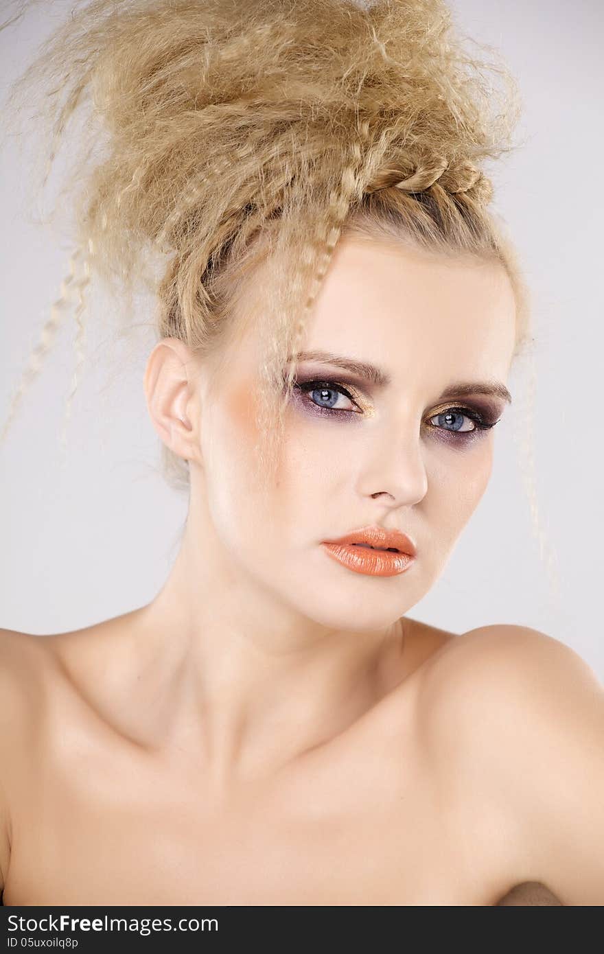 Young pretty woman with beautiful blond hairs and multicolor makeup on white background