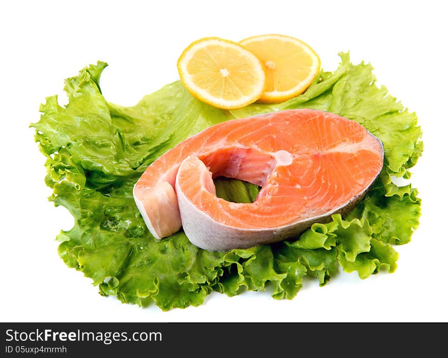 Salmon steak ready to cook at lettuce leaf isolated over white