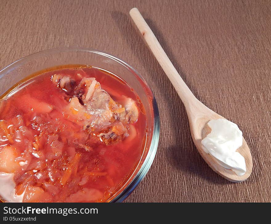 Red soup with chicken and sour cream, wooden spoon. Red soup with chicken and sour cream, wooden spoon