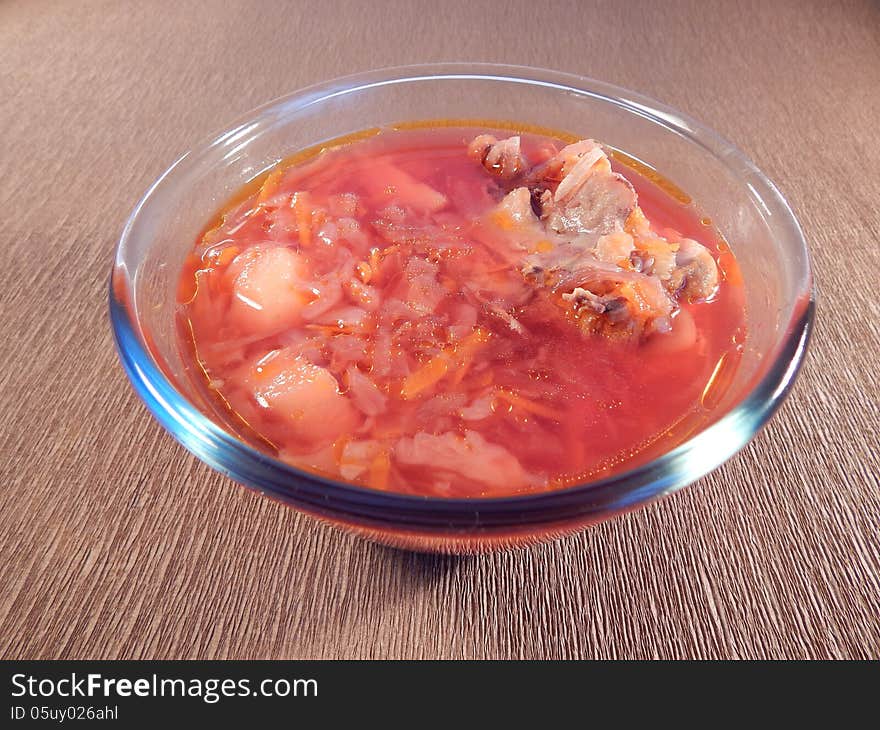 Red soup with chicken on brown background