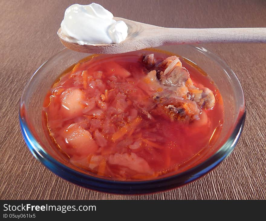 Red soup red soup with chicken and sour cream on a brown background